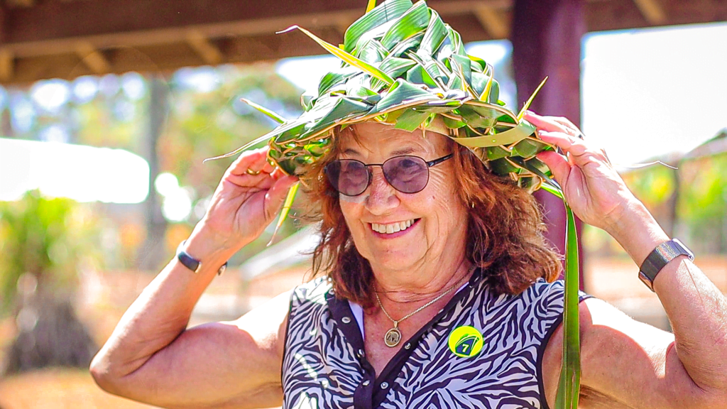 Lady putting on a handwoven hat