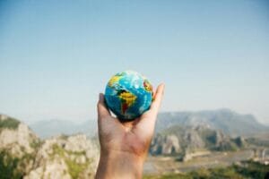 Hand holding up small globe 